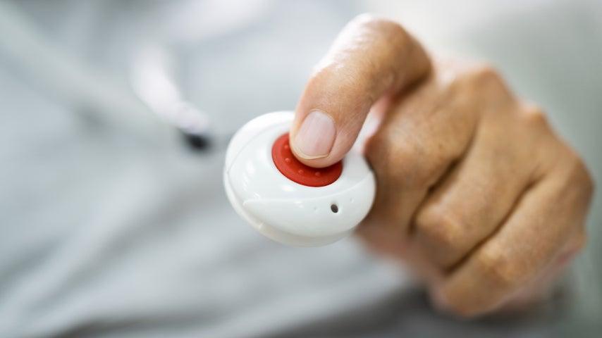 finger pressing a medical alert help button