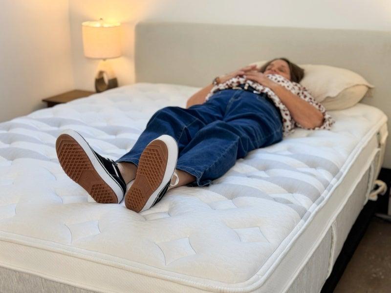 A tester lies on her back on the Leesa Sapira Chill hybrid mattress