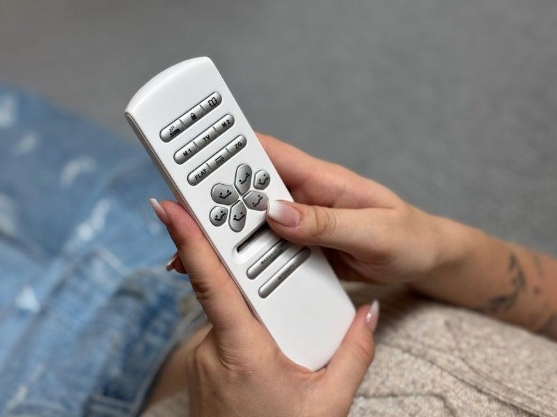 A person holding the Nectar Adjustable Bed Frame remote