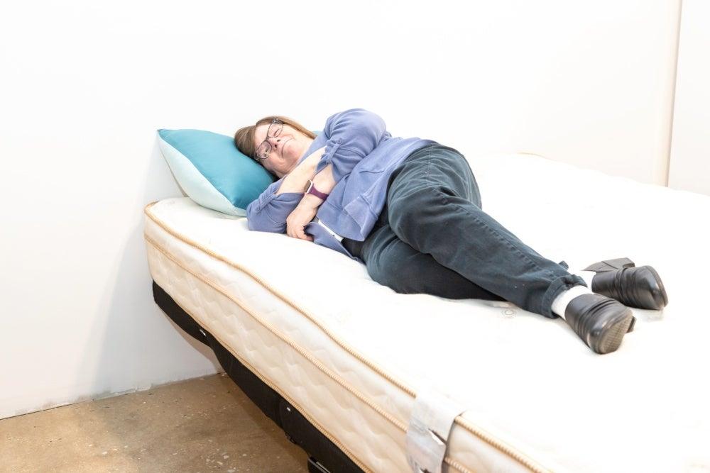 An older adult woman side sleeping on a Saatva Classic mattress