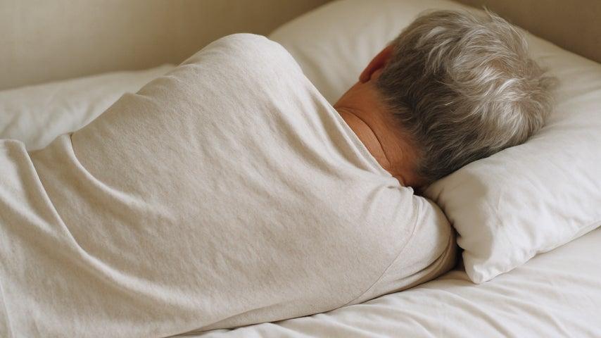 Man sleeps on his side facing away from the camera