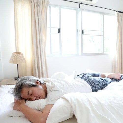 Man lies on his stomach on his bed and sleeps