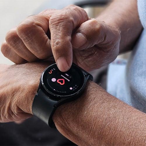 Man pushes touchscreen on the smartwatch he’s wearing on his left wrist