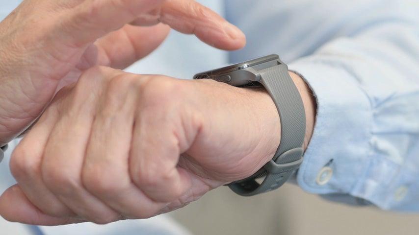 man's hand about to touch smartwatch