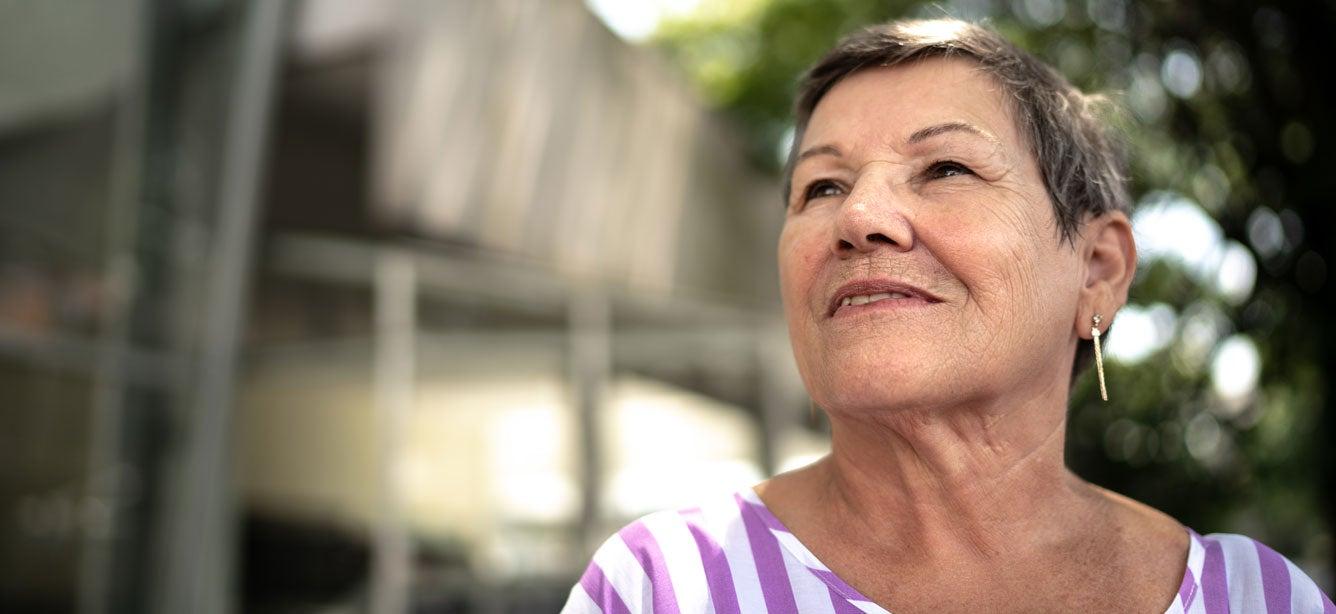 Senior Hispanic woman gazing up outside