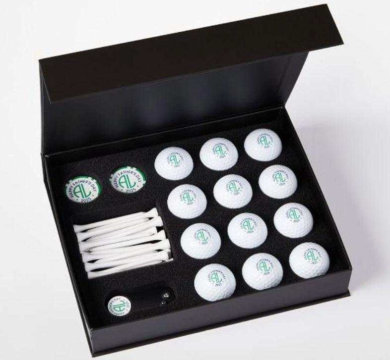 Golf set showing a box containing monogrammed golf balls, tees, poker chips and a divot tool