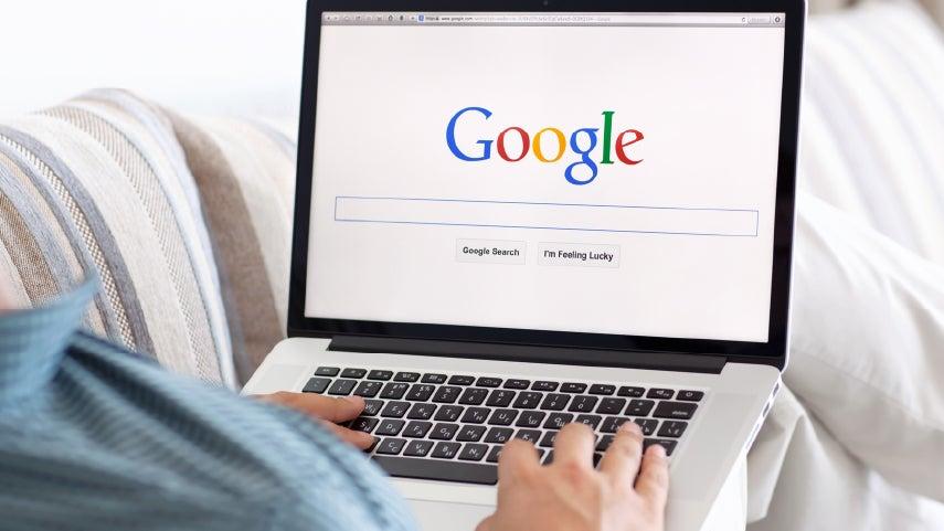 Superimposed image of someone holding a laptop on their lap with a Google search bar front and center.