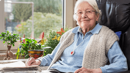 smiling older woman wearing medical alert necklace