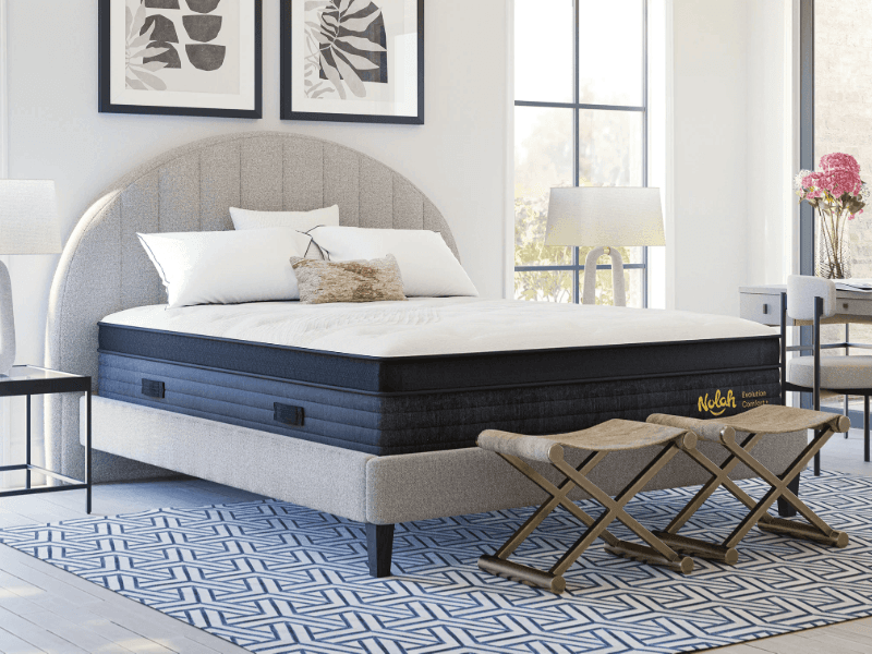 The Nolah Evolution Comfort+ mattress on a grey bedframe in a bedroom