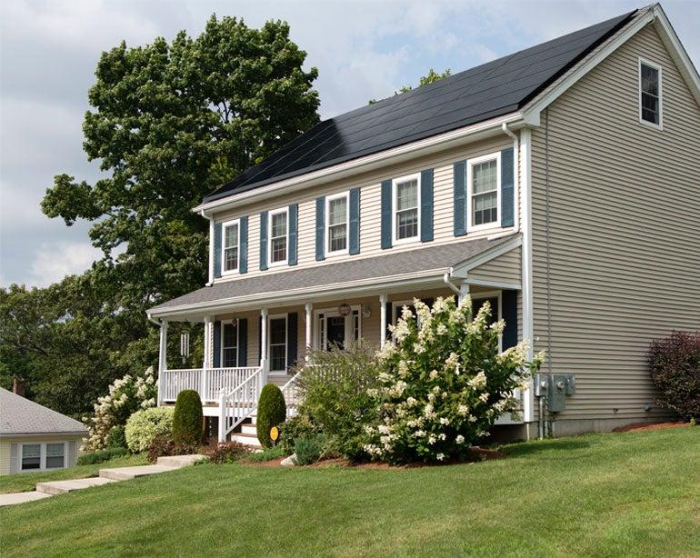 A street view of a single-family home that has solar panels on its roof.