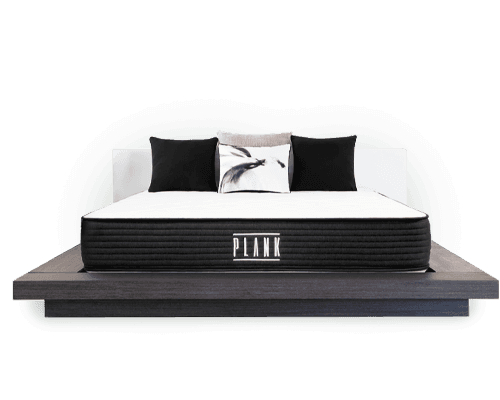 Plank firm mattress on raised bed frame with pillows