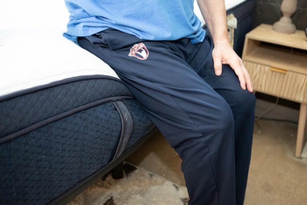 A man sitting on the side of the Aurora Luxe Cooling mattress.