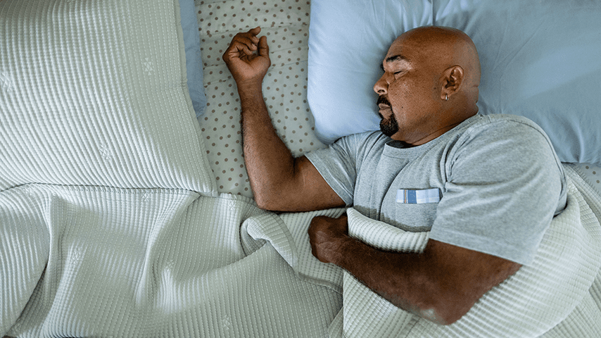 bald man with dark mustache and goatee asleep on his side