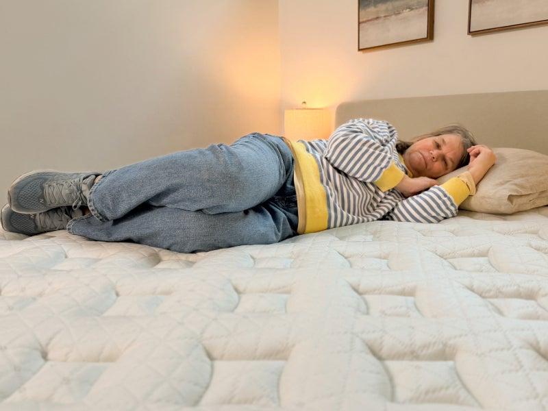 A woman lying on her side on the Helix Sunset mattress