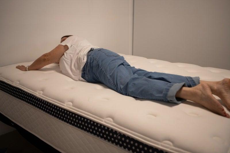 A woman lying on her stomach on the WinkBed Plus mattress