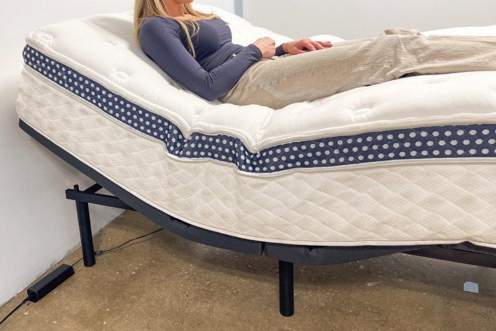 A woman lying on a WinkBed Luxury Firm mattress in and adjustable bed frame