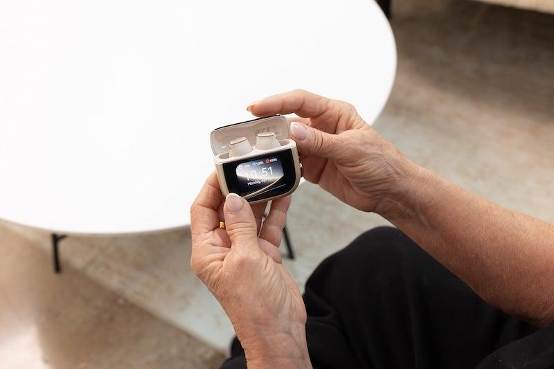 Hands opening the touchscreen-enabled charging case of the Cearvol Wave