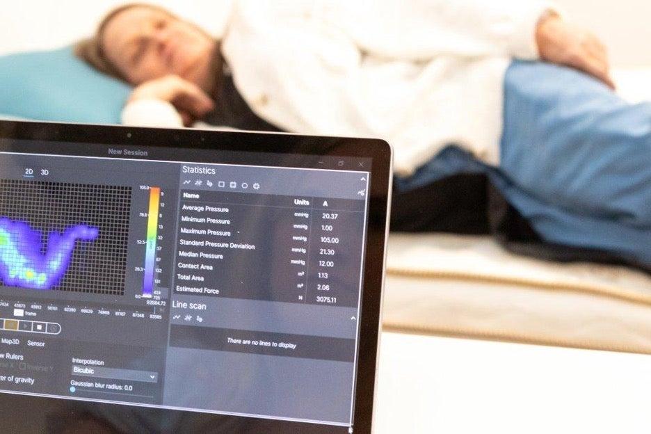 A pressure map reading of a woman lying on the Saatva Classic mattress on her side.