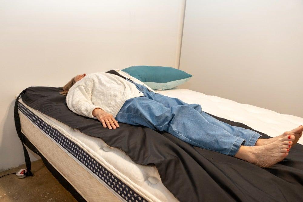 A woman lies on her back on the WinkBed Luxury Firm mattress