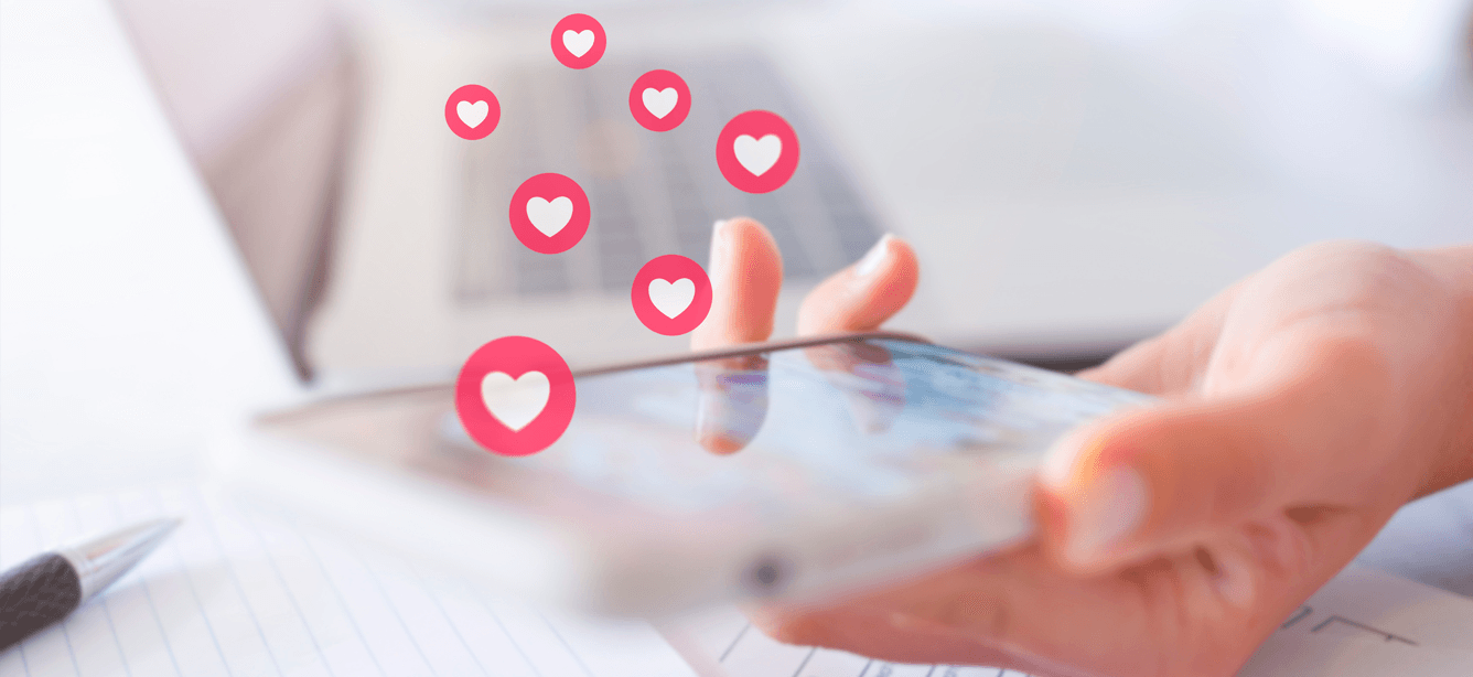 Several emoji hearts are flying above a phone, indicative of online dating.