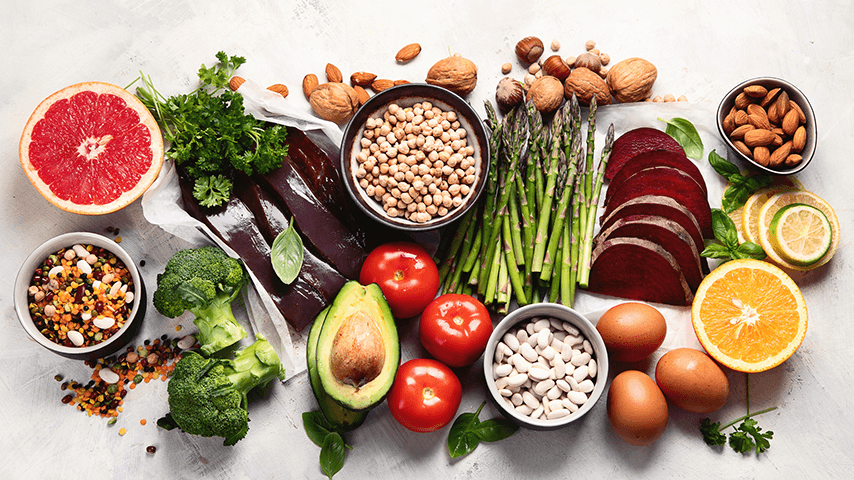 collage of healthy foods including avocado, tomatoes, nuts, and grapefruit