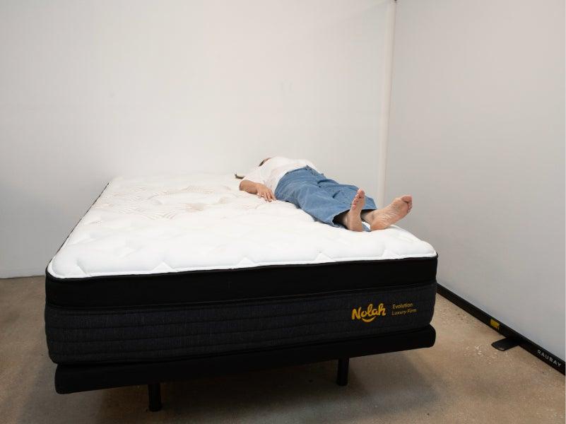 A woman lying on the edge of the Nolah Evolution mattress