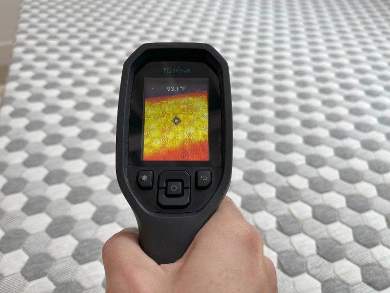 A tester measures the temperature of the Layla mattress topper