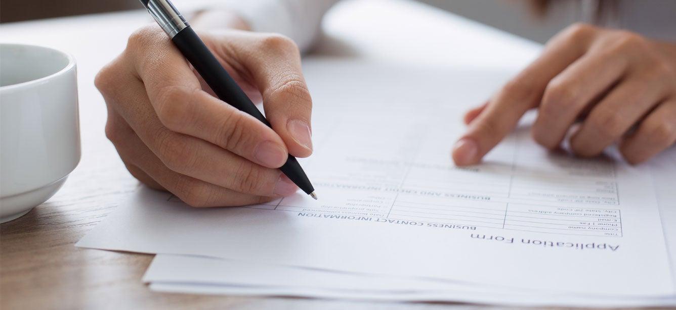 An up-close shot of someone filling out an application.