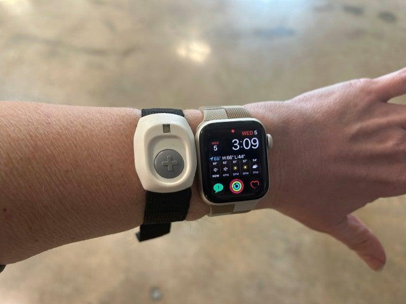 The Medical Alert Smartwatch next to one of the Home system’s help buttons on a man’s wrist