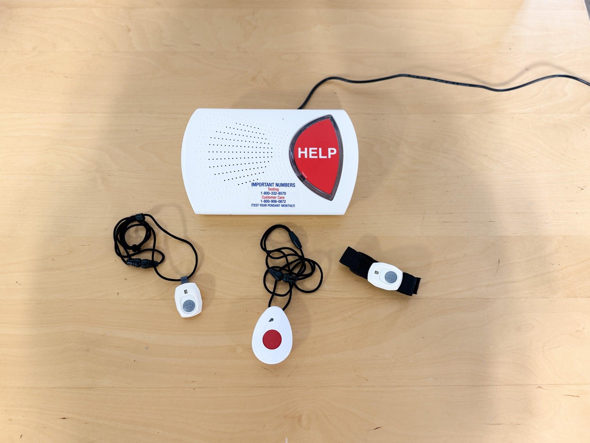 The Medical Alert Home device's base station and wearable buttons