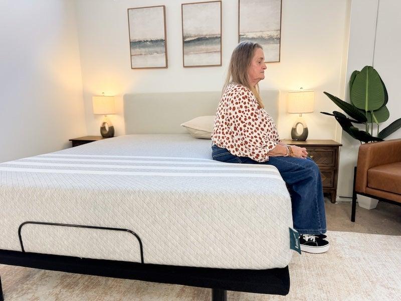 A woman sits on the edge of the Leesa Original memory foam mattress