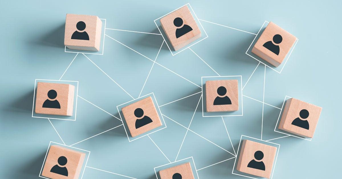 A Black senior woman and her husband are sitting on the couch looking at something on their tablet.