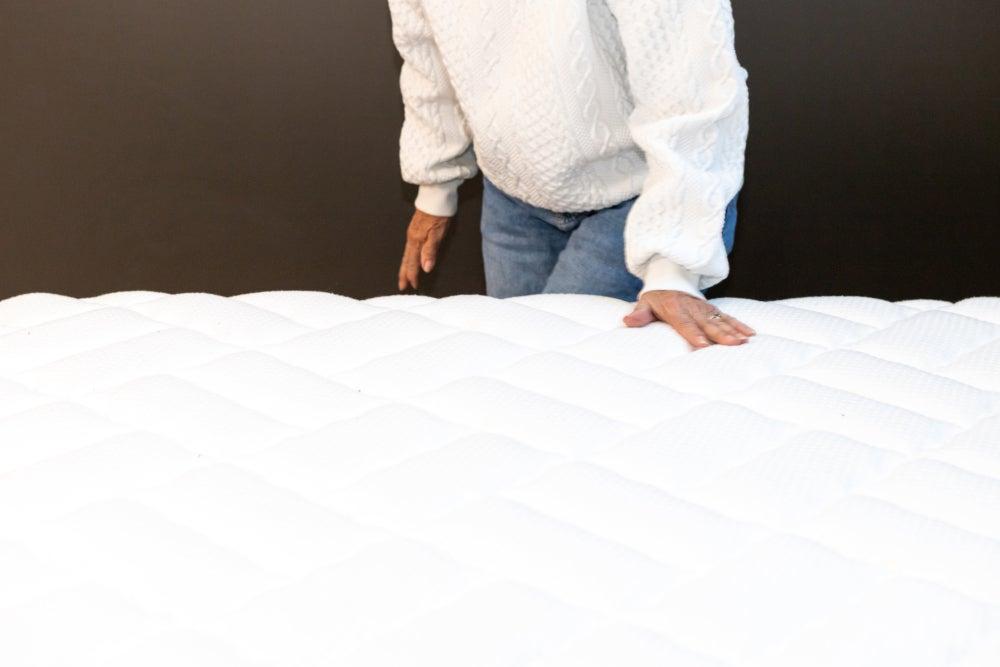 person feeling the cover of the Titan Plus mattress