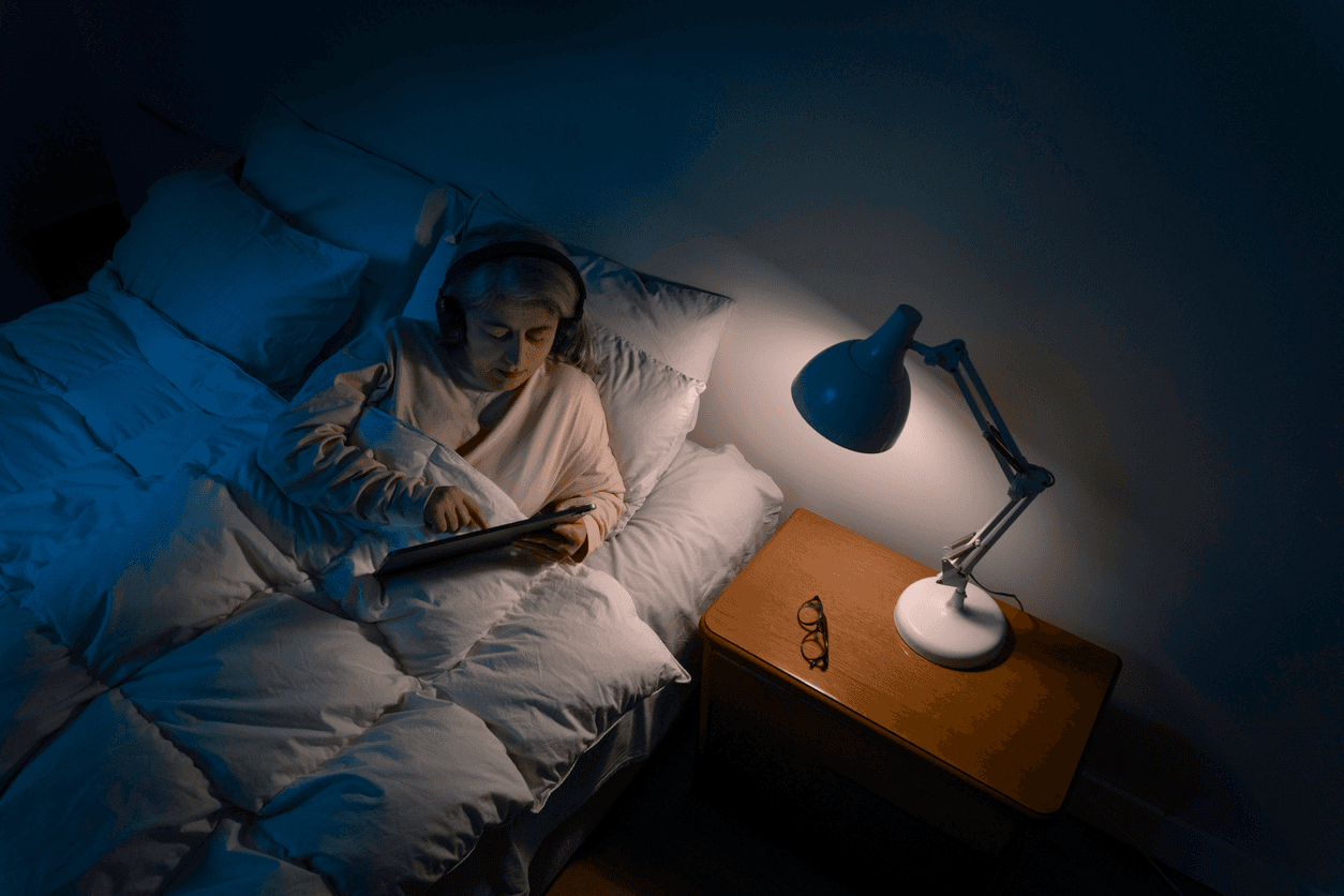 Older woman reading in bed at night