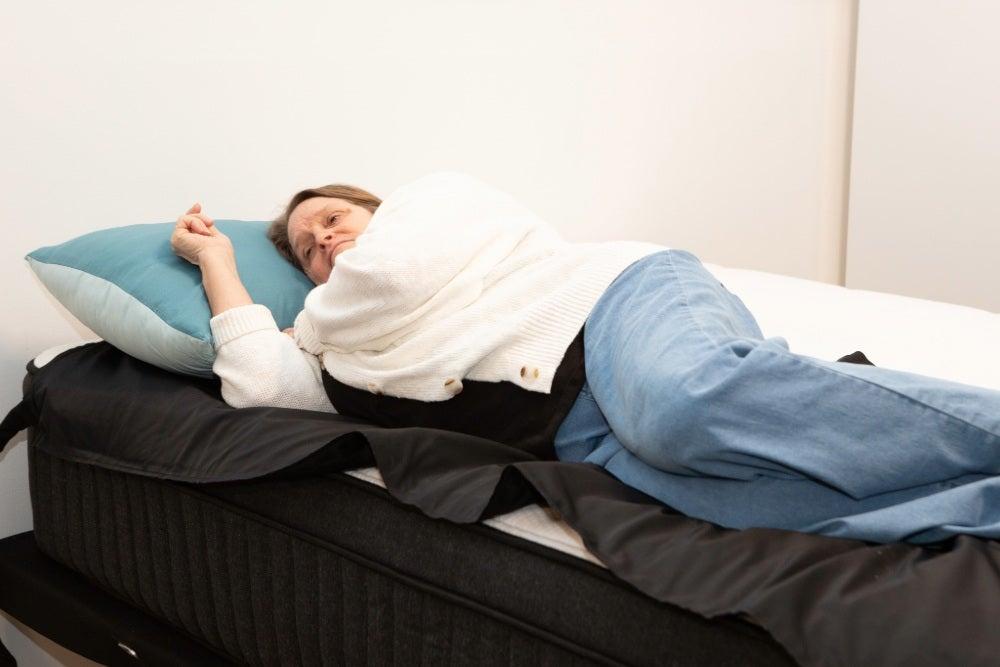 A woman lying on a pressure map placed over the Titan Plus Luxe mattress
