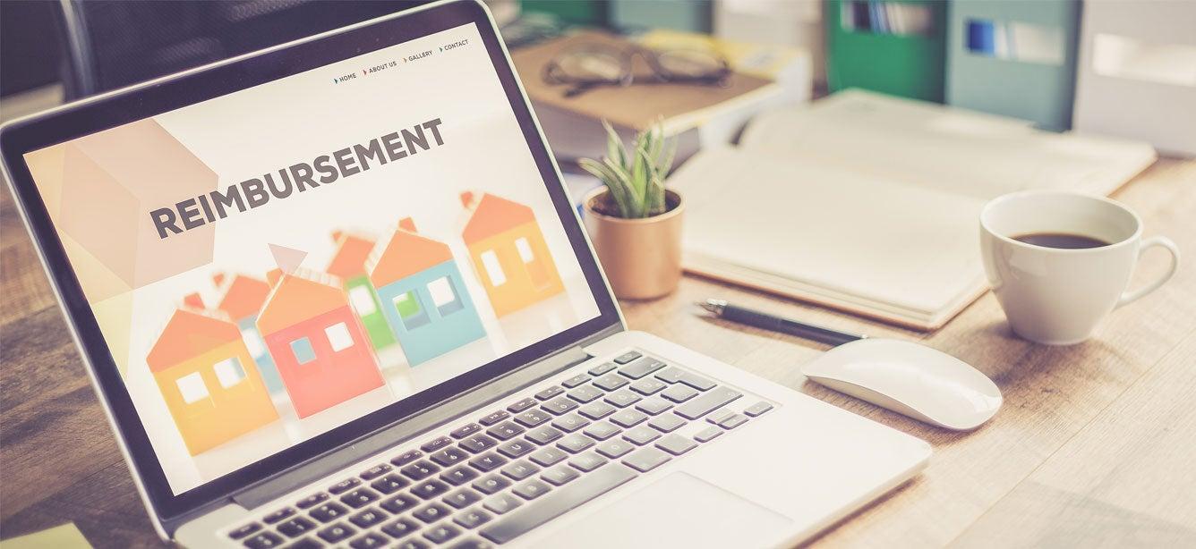 A laptop computer screen shows the word "REIMBURSEMENT".