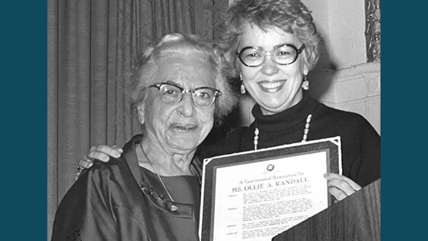 Ollie Randall receiving award from smiling woman