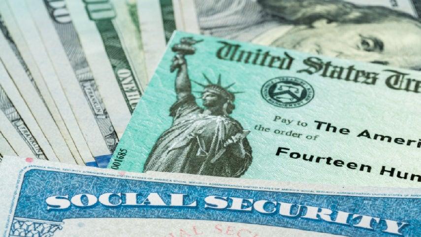 Close up of a social security card sitting on top of U.S. dollar bills.