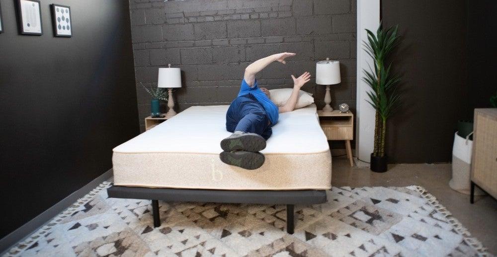 Man lies on his side on the Birch Natural mattress and rolls to his left side