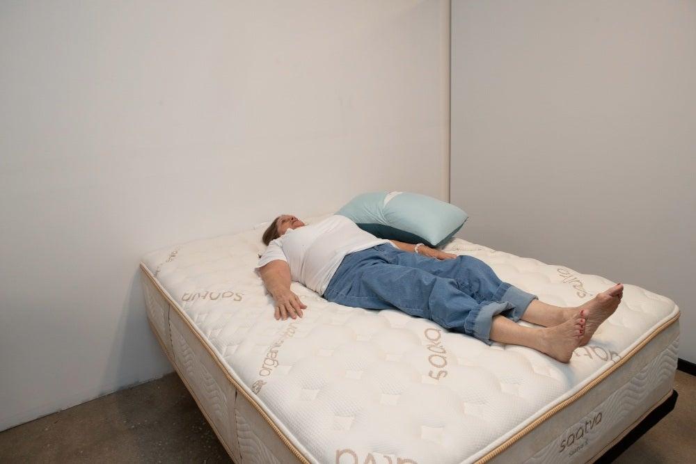 A woman lying on her back on the Saatva Rx mattress