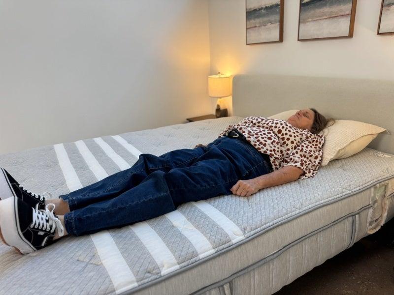 A woman lying on her back on the Leesa Plus mattress