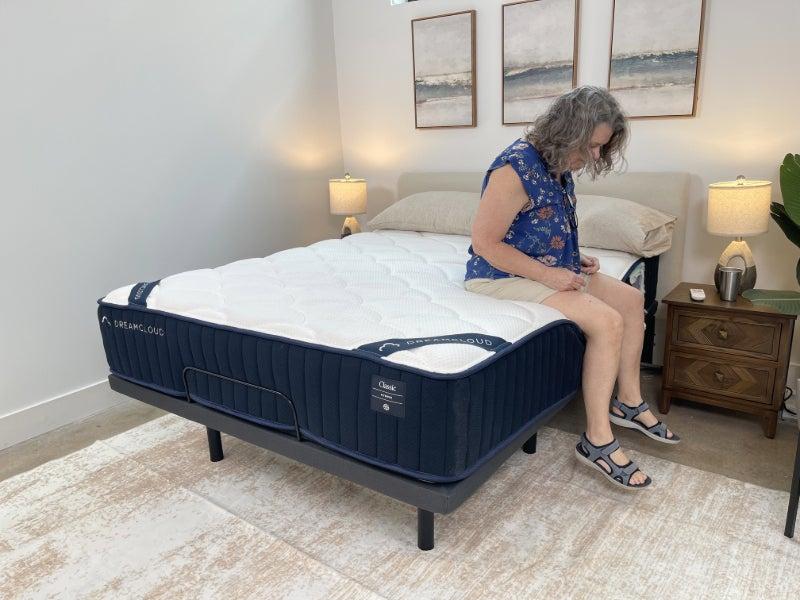 Person sitting at the edge of the DreamCloud Classic Hybrid