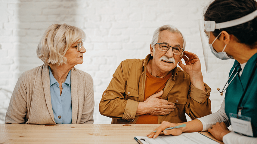 concerned looking older man with older woman speaking to doctor