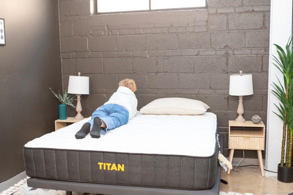 A woman rolling onto her stomach on the Titan Plus Luxe mattress