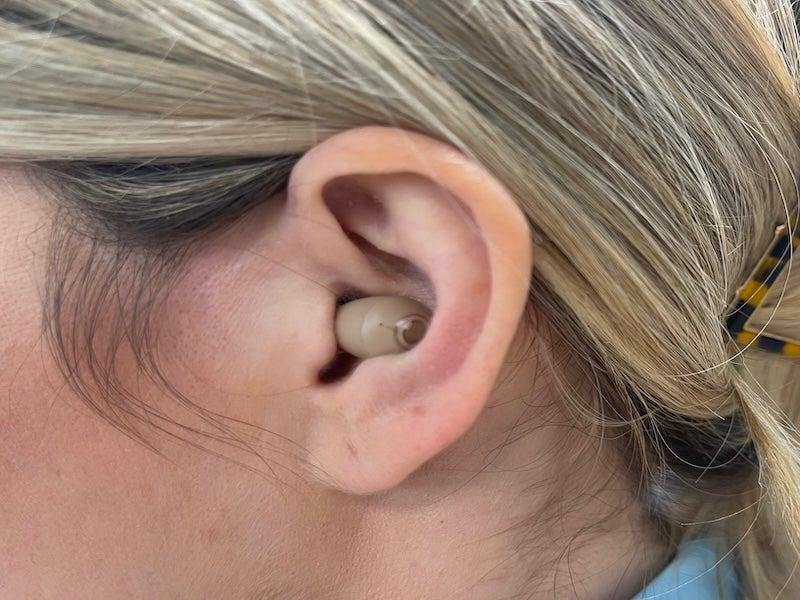 Woman wears the Audien Atom Pro beige colored hearing aid