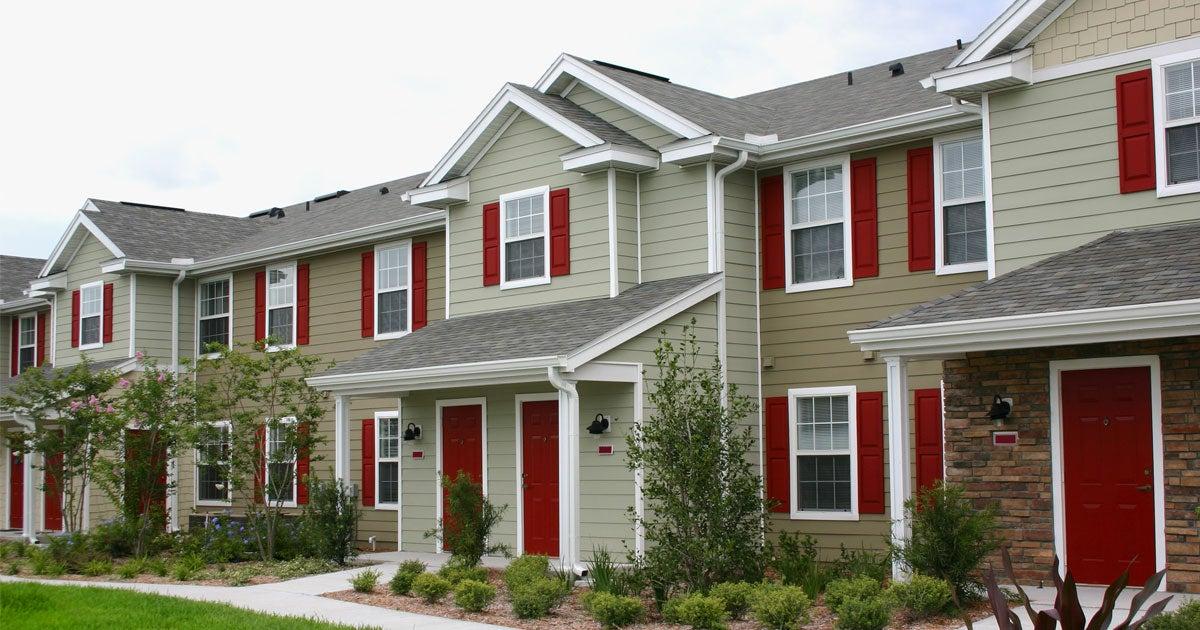 A street view of a row of new houses in a suburban neighborhood.