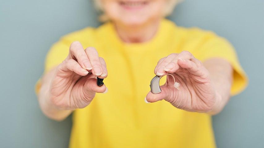 woman's outstretched hands holding Jabra hearing aids