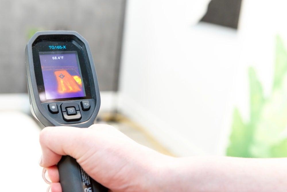 A temperature gun pointed at a bed