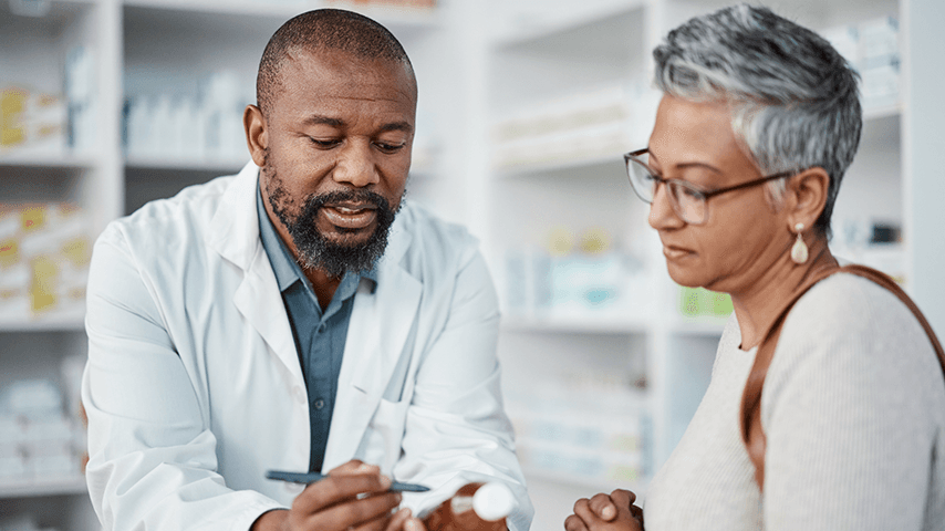 pharmacist talking to older woman about a medication