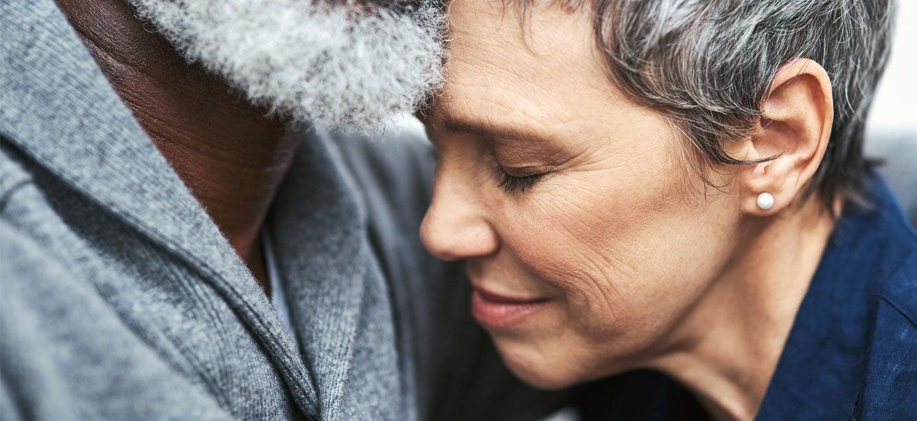 A Black senior man holds his wife as she struggles with grief.